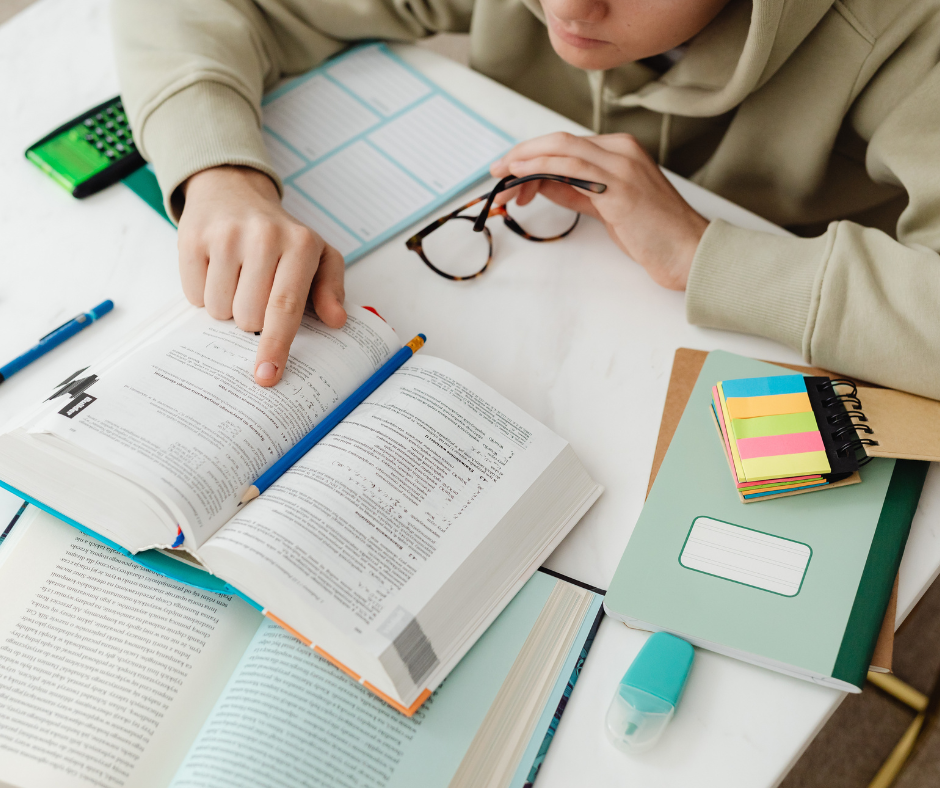 Student studying at a desk with books.